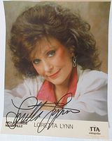 Front view of the signed Loretta Lynn glossy photo showing full autograph and logos.