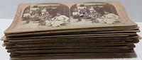 Stack of 37 brown cardboard stereoptic cards, showing aged edges and some curling.