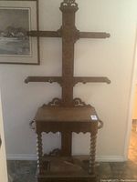 Full view of the antique wooden hall stand showing its structure, umbrella holders, and key design features.