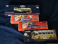 Four boxed models including Vintage Bus Lines streetcar, two Lionel buses, Peoria command bus