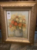 Full view of framed floral painting showing arrangement of white and orange flowers in a blue vase, signed lower right