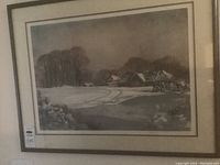 Framed landscape print depicting a snow-covered farm with houses and bare trees under a gray sky. Limited edition, signed and numbered by artist.
