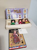 Original box with five vintage dolls in traditional dress representing various nations, with illustrated box lid showing six dolls.
