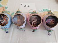 Four heirloom porcelain ornaments from the Bradford Fairy Magic collection arranged in a row showing front fairy images and ornament shapes