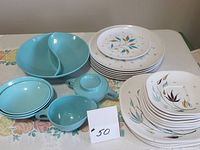 Photo showing full set of 25 retro melamine pieces including plates with floral pattern, star pattern, and turquoise pieces with cups and divided dish.