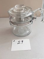 Clear blue-tinted Pyrex flameware coffee percolator with glass lid and handle, showing overall structure and design.