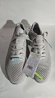 Pair of light gray Crocs LiteRide sneakers size 9 with attached tags, showing top and angled side views with white laces and ventilated design.