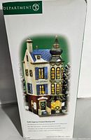 Box packaging showing Department 56 logo and image of the Cafe Caprice French Restaurant figurine with brief text description.