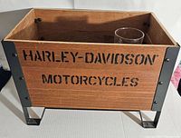 Wooden Harley Davidson crate showing front side with black metal corner brackets and stenciled Harley-Davidson Motorcycles text.