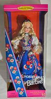 Front side of the box showing Norwegian Barbie doll in traditional blue folk dress with floral embroidery, in original sealed packaging