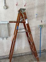 Side view of a 6-foot wooden step ladder showing steps, metal braces, and platform.