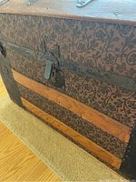 Close-up of the chest's exterior patterned side with a metal lock and latch.