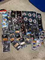 Photo featuring 47 enamel collector pins arranged on a surface, with various themes and designs, many still sealed on original backing cards.