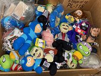 Photo showing a mix of 87 new plush toys with multiple recognizable characters like Blue from Blue's Clues, Ninja Turtles, and others in a cardboard box.