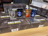 Four collectible Call of Duty Infinite Warfare shot glasses displayed in front of sealed boxes.
