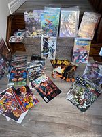 Collector comics arranged on stairs and floor, mostly sealed in plastic bags and boards, showing diverse titles and illustrated covers