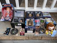 Wide view showing all included figures and collectibles in their boxes on a flat surface