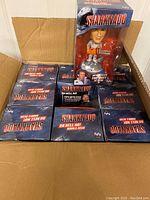 Nine boxed Sharknado bobblehead figures in an open cardboard box, showing overall lot quantity and packaging.