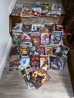 Photo displaying full spread of 40 variant cover comic books arranged on stairs and floor, showing front cover artwork and titles like Hellboy, Red Sonja, Doctor Who, Sonic Universe, Assassin's Creed.