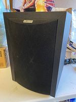 Front view of Polk Audio powered subwoofer with black fabric grille and logo.