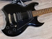 Close-up of guitar body showing controls, pickups, and finish marks.