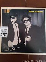 Front album cover of Blues Brothers 'Briefcase Full of Blues' vinyl LP showing two members in black suits and hats.