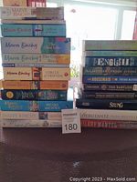 Two stacks of assorted fiction books on a table, including a significant collection of Maeve Binchy novels, and other assorted authors.