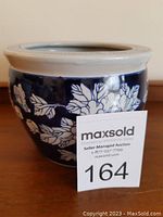 Side view showing dark blue body with white flower and leaf decoration and seller item number.