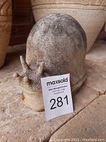 Side view of faux stone resin snail showing texture and shell detail with auction card
