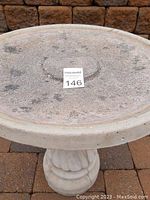 Top view showing the removable round bird bath tray with textured surface and minor discoloration.