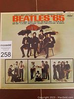 Front cover of Beatles '65 album featuring the band with umbrellas and smaller inset photos.