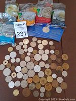 Top-down view of coins spread out with five packages of Canadian coin wrappers in background and a card about commemorative coins in center.