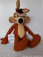 Front view of vintage Warner Brothers Wile E. Coyote plush toy sitting upright showing facial details and overall condition.