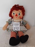 Front view of the doll showcasing facial features, dress, and stockings.