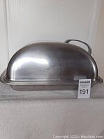 Side view of the large aluminum turkey roasting pan with dome-shaped lid and side handle, showing the overall size and metallic finish.