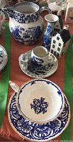 Full lot showing Coalport cup and saucer, Ming jug, Delfts mouse trays, and KLM Delft houses from an angle.