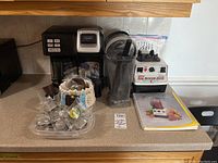 Full lot display with coffee maker, two blenders, reusable pods, filters, and manuals.