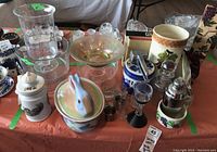 Full overview of glass and ceramic serving ware lot including lidded bunny dish, footed bowl, canister, wine cooler, and barware