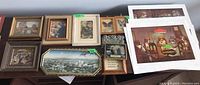 Photo showing various framed prints and butterfly art pieces arranged together, frames in wood and metal