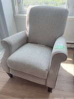 Front view of beige fabric manual La-Z-Boy recliner chair with well-padded seat and armrests, showing overall condition and fabric texture.