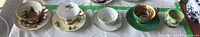 Composite shot of four teacup & saucer sets and Sterling sugar bowl