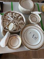Three cases open showing cups, saucers and dinner plates inside