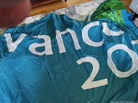 Close-up photo of the folded rip-proof fabric banner showing partial 'vancouver 2010' text and blue and green graphics.