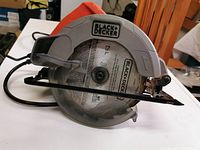 Side view of BLACK+DECKER BDECS200C circular saw showing blade guard, blade size marking, and orange handle