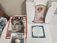 Lot items including Time Magazine, Elton John memorial CD, Royal Bradford Exchange plate, and certificate of authenticity
