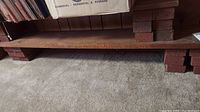 Side view of wooden board supported by red bricks in basement setting