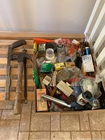 View of the hardware box showing various tools, nails, tapes, and electrical components inside. Items appear used and need cleaning.