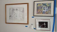 Wall showing all three framed art pieces hung side by side with visible size variation and mounting tags.