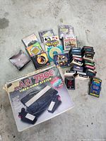 Full lot view showing Atari 7800 console box, two joystick controllers, multiple game cartridges and computer game discs