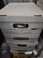 Closed white Bankers Box labeled 'Baseball Cards' containing loose trading cards